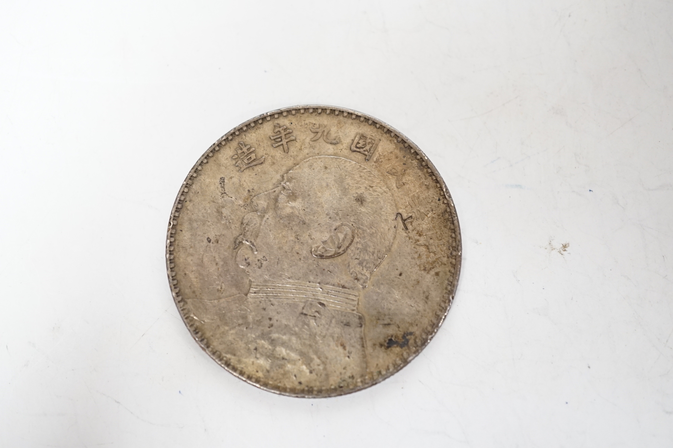 A Chinese Republic period one dollar 1920, and two Chinese Guangxu period coins mounted as miniature furniture, table 4vm higher